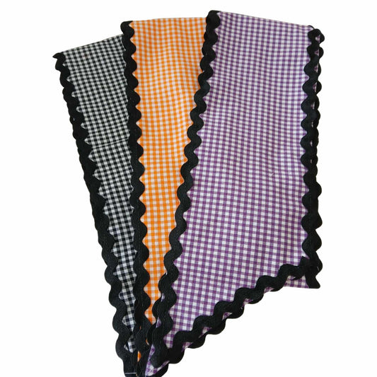Three gingham checkered wreath sashes with black scalloped edges on a white background.